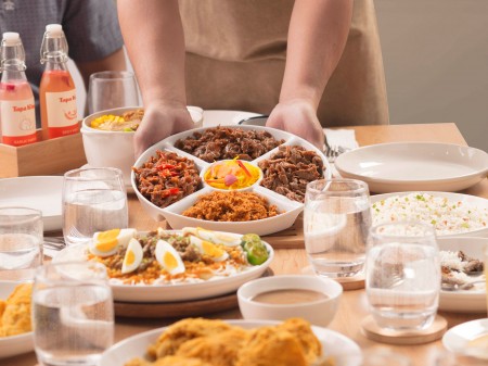 Close-up shot of a Tapa King feast served by a waiter. art directed and photographed by Bluethumb